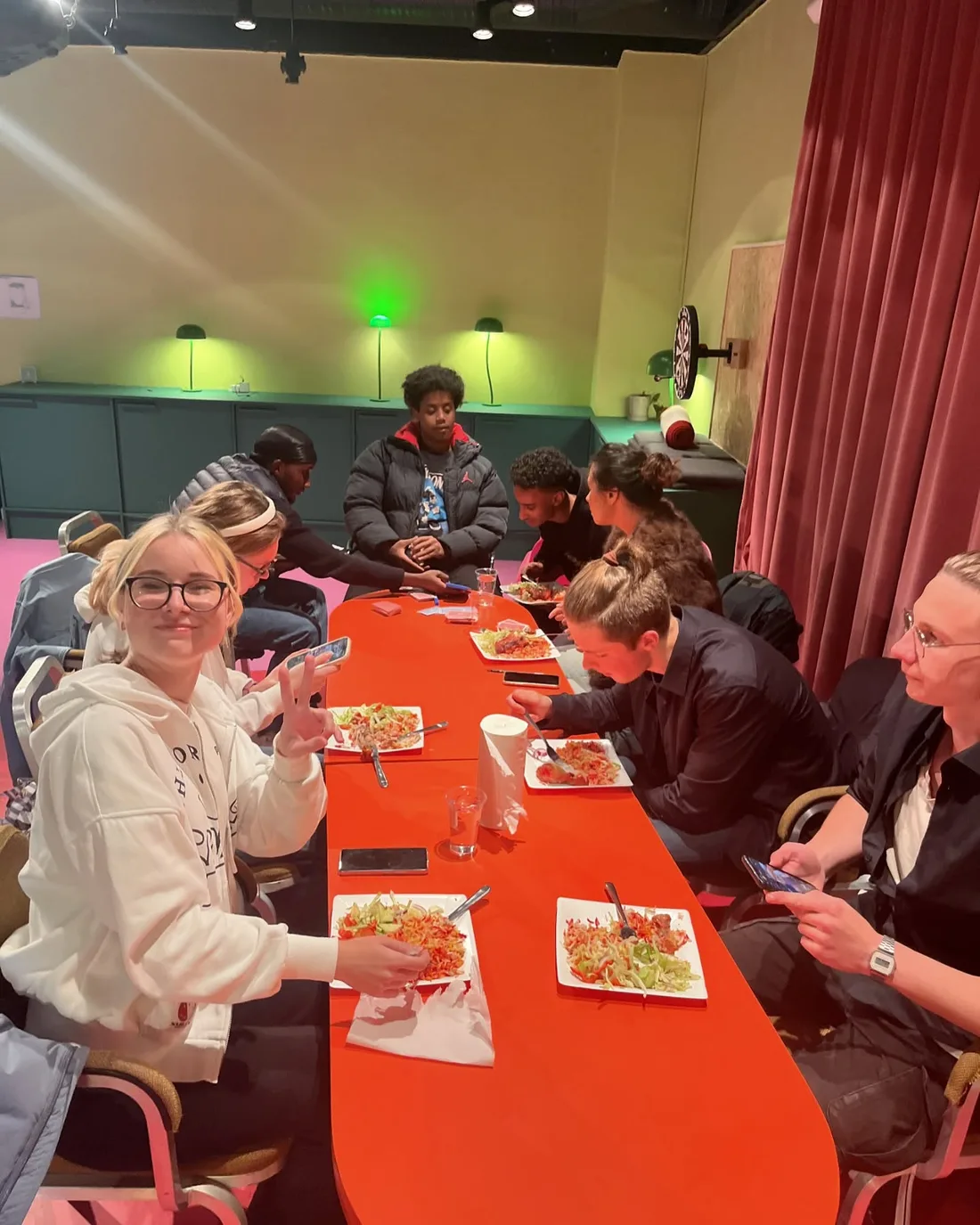 Deltakere rundt et langbord under et felles måltid